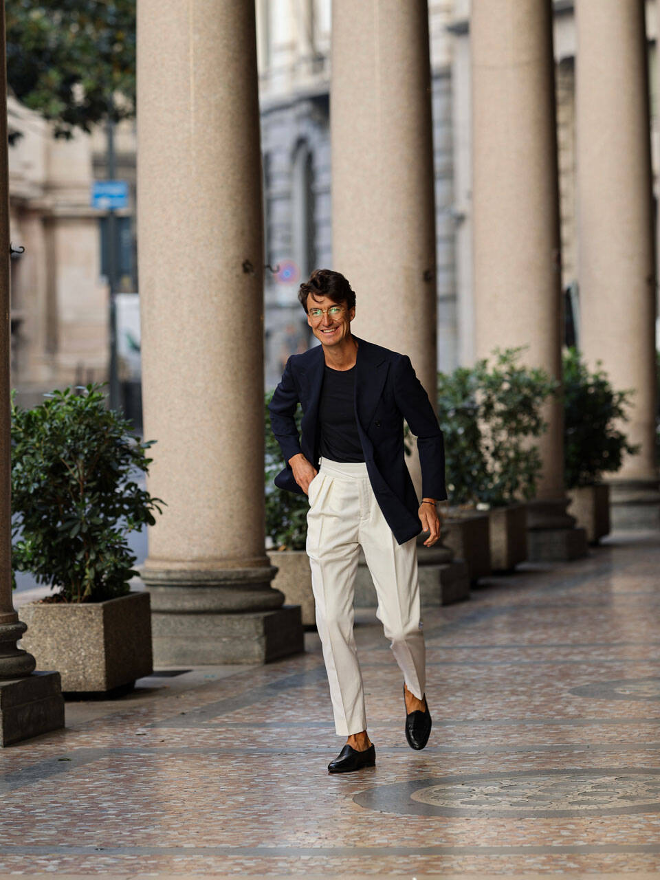 a man in white pants and a blue jacket