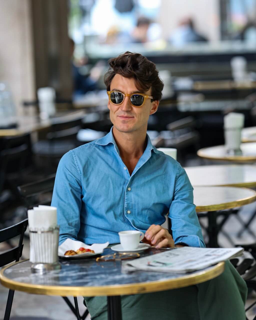 a man in a stylish shirt and sunglasses with a coffee