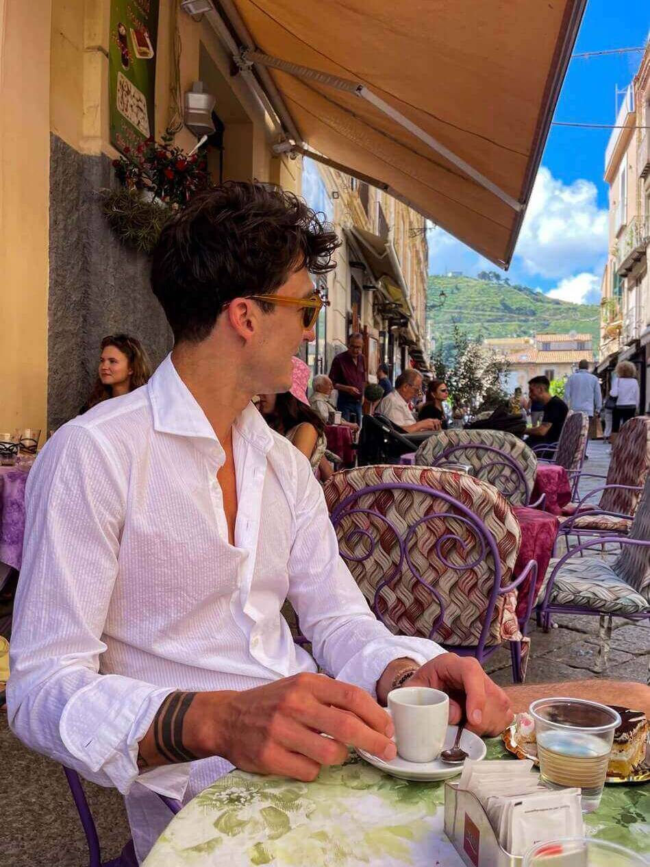 A man in a white shirt with an espresso.