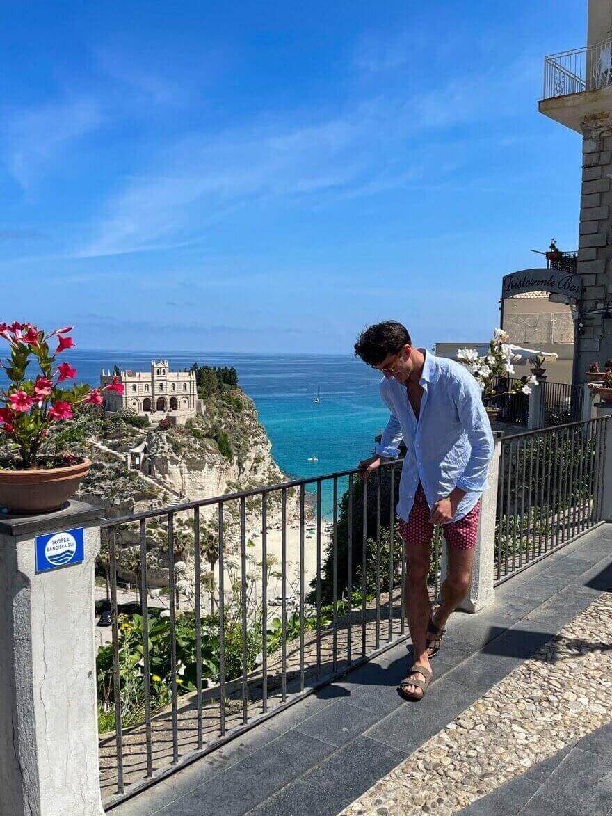 a man in a blue shirt and red polka-dot shorts