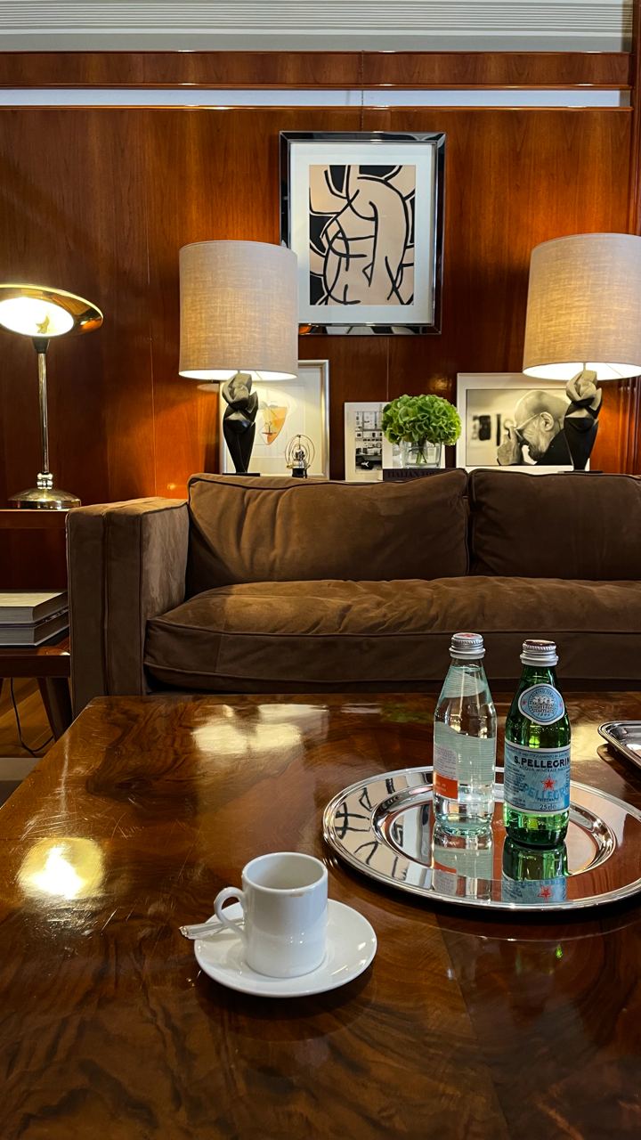 Elegant lounge area with stylish decor, featuring a plush brown sofa, modern lamps, and a table set for refreshments, captured during an in-person personal styling session in Milan