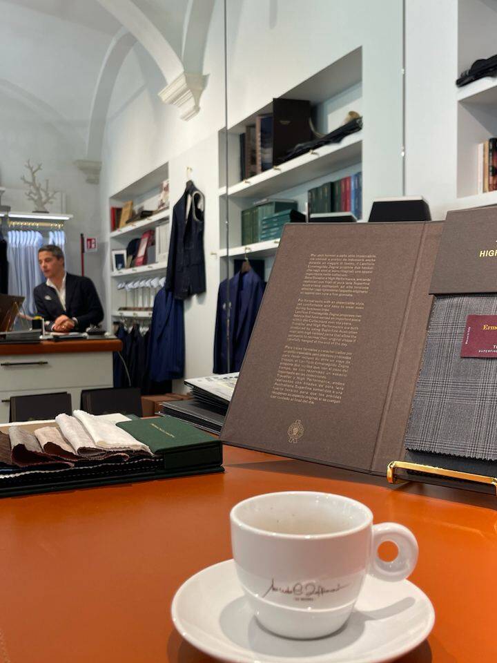 A cup of espresso on a table with fabric samples during a personal styling session in Milan, showcasing personalized wardrobe creation