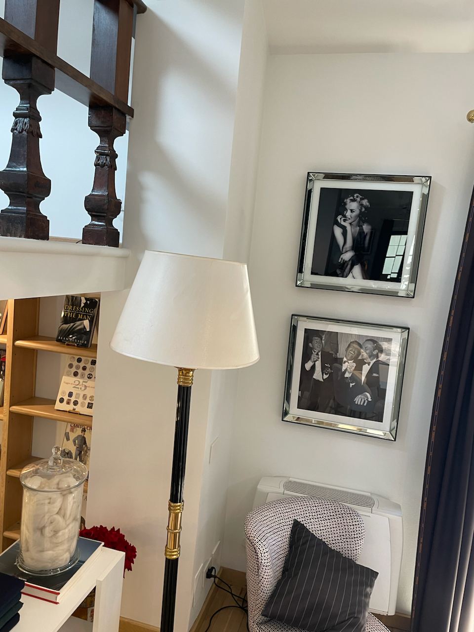 Boutique interior with white walls, featuring two paintings: one of a gentleman and the other of Marilyn Monroe.