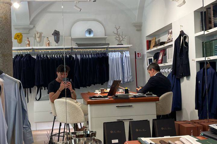 Personal stylist in a Milan boutique preparing outfits for in-person styling session with a focus on a gentleman's wardrobe