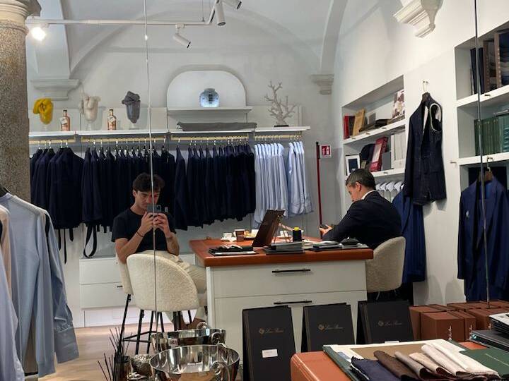 Personal stylist in a Milan boutique preparing outfits for in-person styling session with a focus on a gentleman's wardrobe